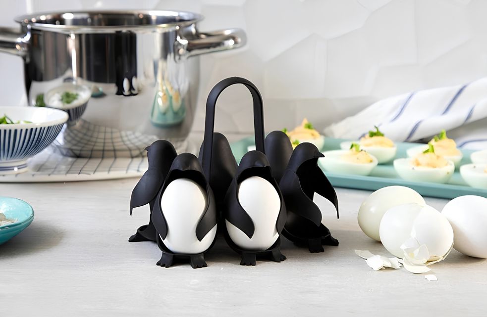 Egguins eierhouder van Peleg Design met zes zwarte pinguïns en witte eieren op het aanrecht