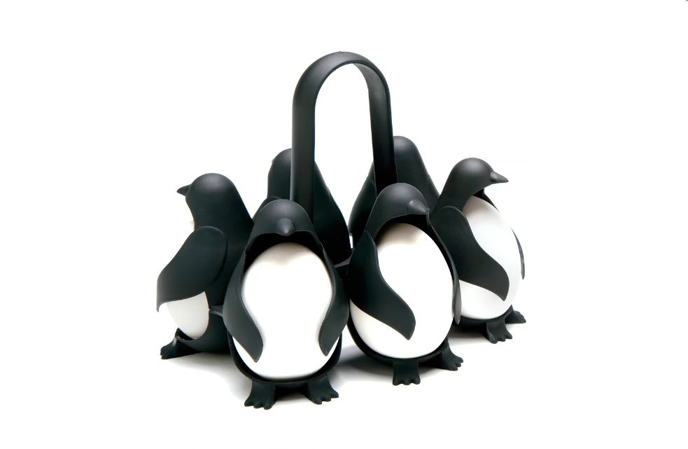 Zwarte Egguins eierhouder van Peleg Design met zes pinguïns, witte eieren en een centraal handvat op witte achtergrond