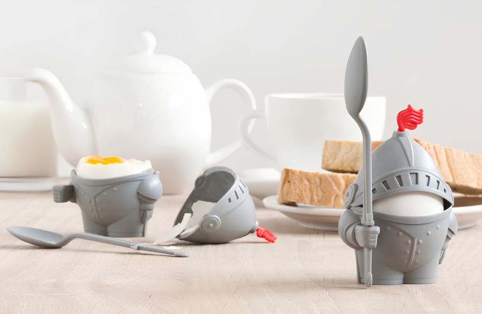 Twee Peleg Sumo Eggs eierdopjes in rood en zwart met gekookte eieren op een gedekte ontbijttafel