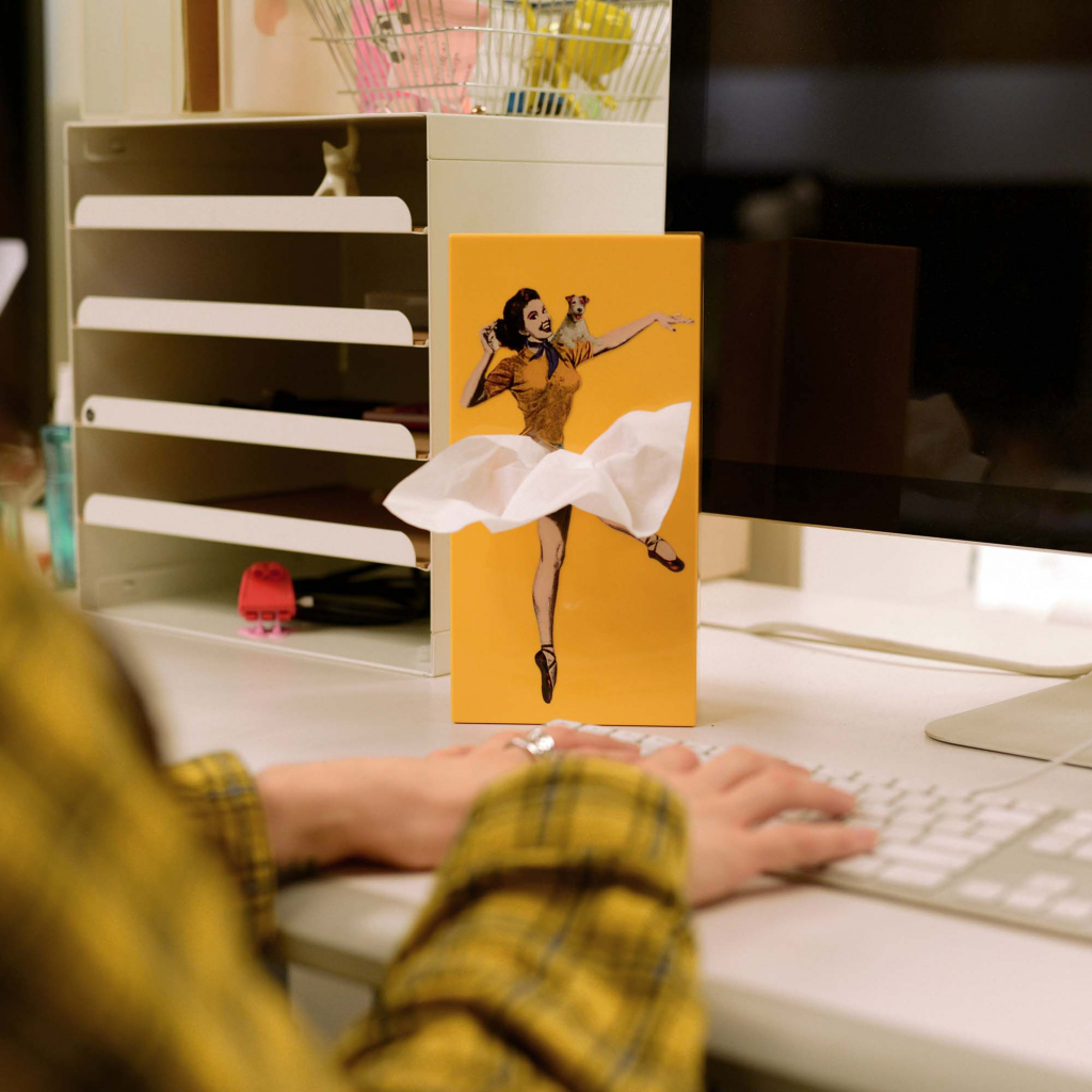 Oranje SPEXTRUM Tissue Up Girl tissuehouder op een bureau